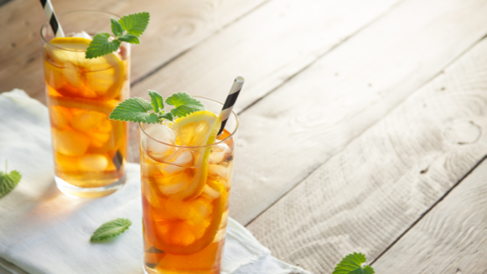 Long Island Iced Tea servido con abundante hielo, rodajas de limón y hojas de menta, un cóctel clásico de verano ideal para disfrutar en terrazas y reuniones al aire libre.
