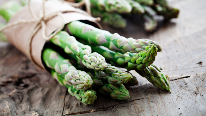 Espárragos verdes frescos sobre mesa de madera en temporada de primavera