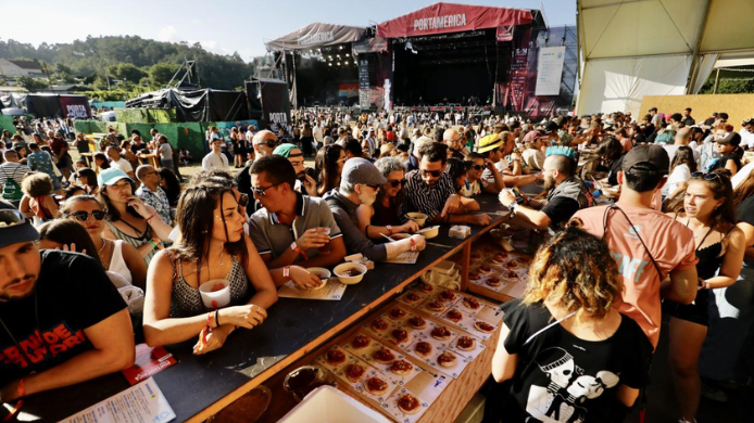 Asistentes disfrutando de propuestas gastronómicas frente al escenario principal de PortAmérica, el festival gallego que combina música en directo y cocina de autor en un mismo espacio.