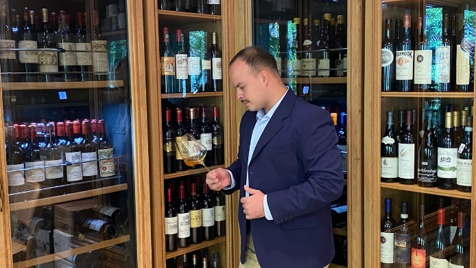 Lorenzo Rodrigues, jefe de rango en Amazónico Madrid, catando una copa de vino junto a la bodega del restaurante