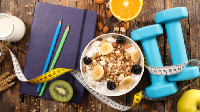 Tazón de desayuno saludable, mancuernas y cinta métrica