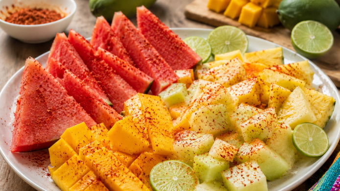 Fruta con sal y chile servidas en una bandeja para el verano