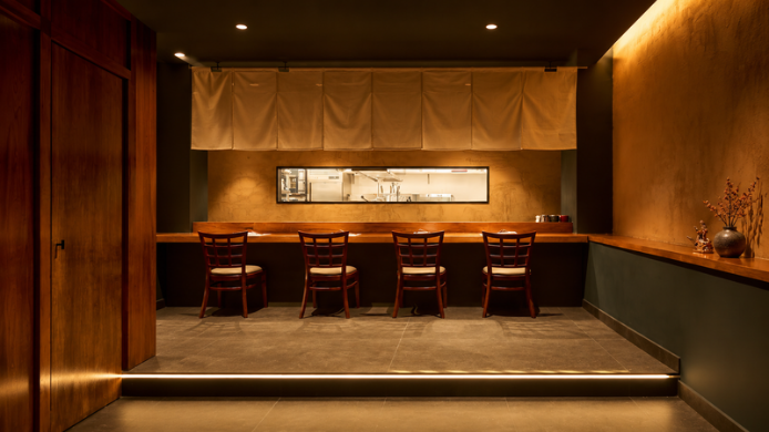 Interior de Shishimaru Madrid con barra de madera, cocina vista y una estética japonesa sobria e íntima.