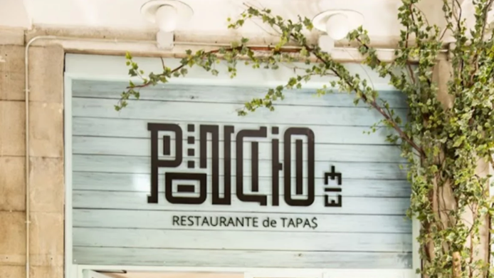Cartel exterior de Poncio by Willy Moya en Madrid, con el nombre del restaurante sobre una fachada de madera clara decorada con vegetación trepadora.