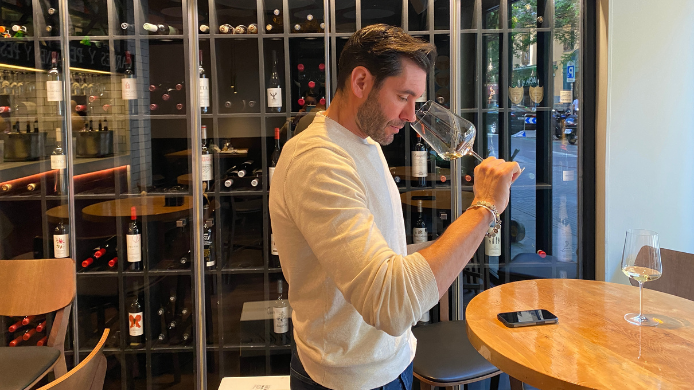 Alberto Rivera, sumiller, catando una copa de Lafou Els Amelers en un espacio de bodega y sala de restaurante, imagen representativa de la sección Un Vino, Un Sumiller.