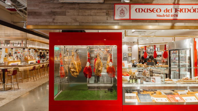 Interior de Museo del Jamón con piezas colgadas y barra de tapas en Mercado Little Spain de Nueva York