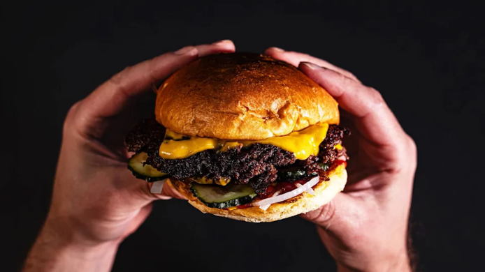 Manos con una smash burger