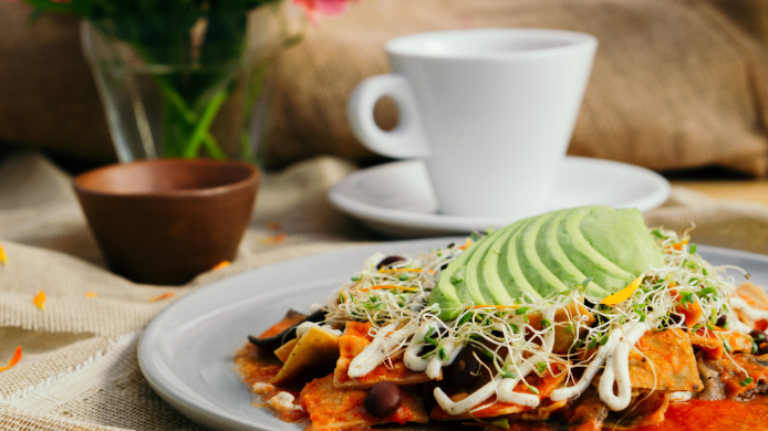 Desayuno mexicano tradicional con chilaquiles, aguacate y café frente al auge del brunch