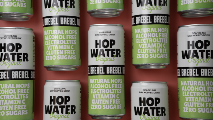 Latas de Hop Water Original de Brebel, la primera bebida elaborada en España con agua carbonatada y lúpulo natural, sin alcohol, sin gluten, sin azúcar y enriquecida con vitamina C y electrolitos.