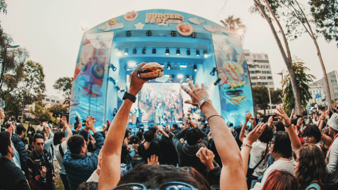 Público disfrutando de conciertos y hamburguesas durante el Burger Fest en Lima frente al escenario principal del festival gastronómico.