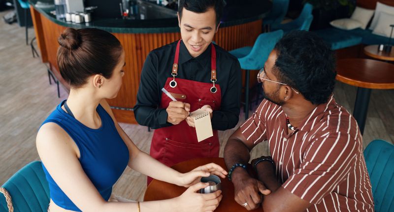 profesional de sala en gastronomía atendiendo clientes